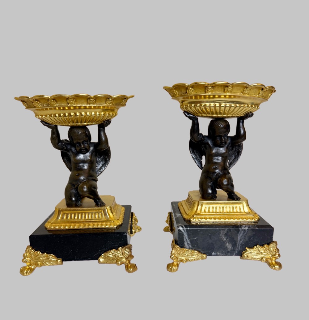 A pair of nineteenth-century gilt bronze and black marble tazzas featuring dark bronze winged cherub figures supporting fluted shallow bowls. View VIII