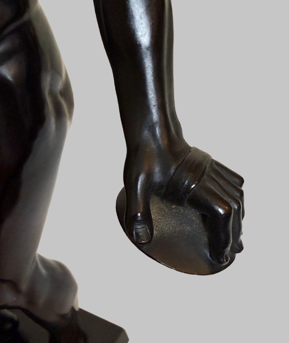 A dark patinated bronze statue depicting a nude classical dancing faun holding cymbals, mounted on a square black base. View VIII