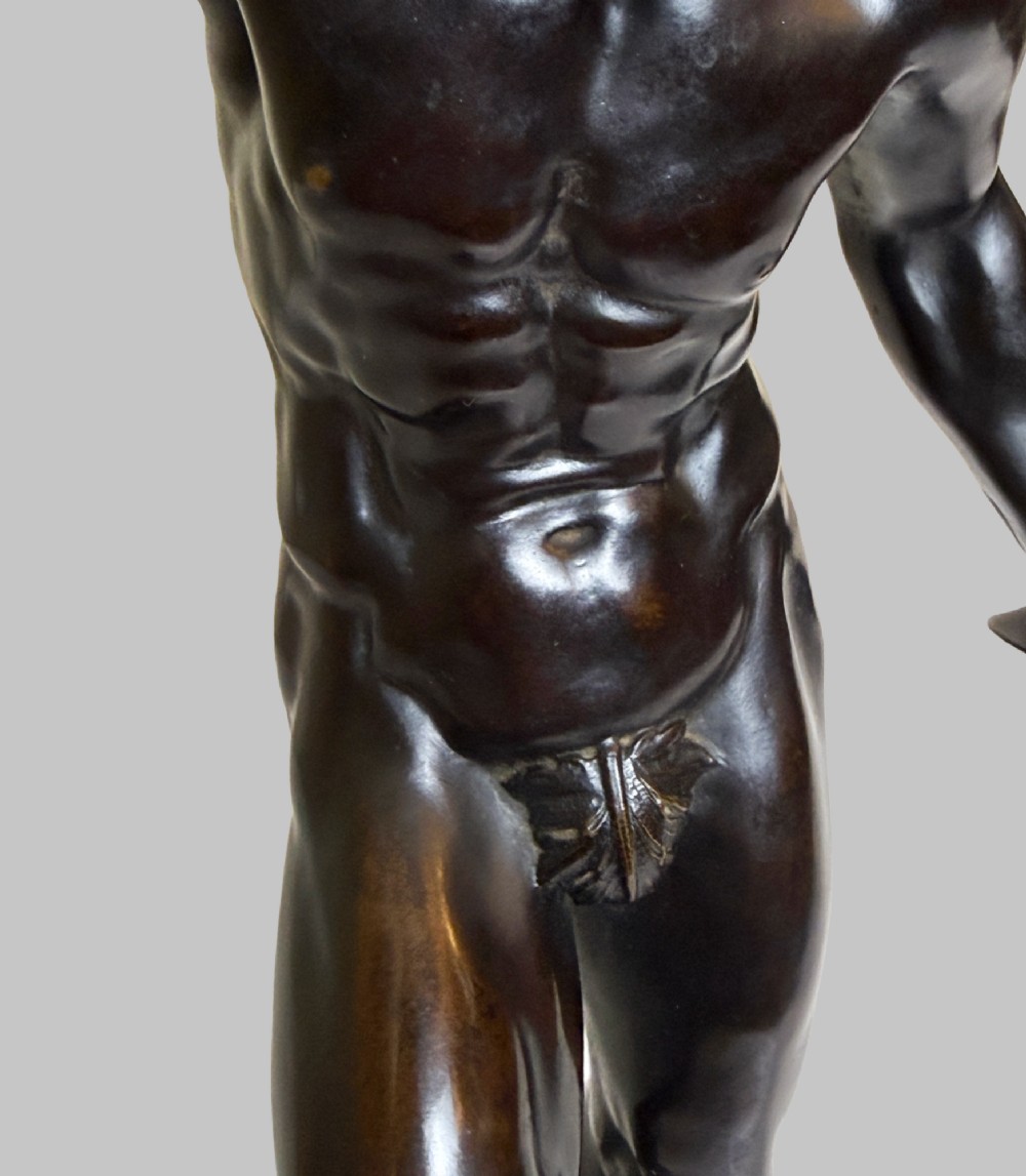 A dark patinated bronze statue depicting a nude classical dancing faun holding cymbals, mounted on a square black base. View IX