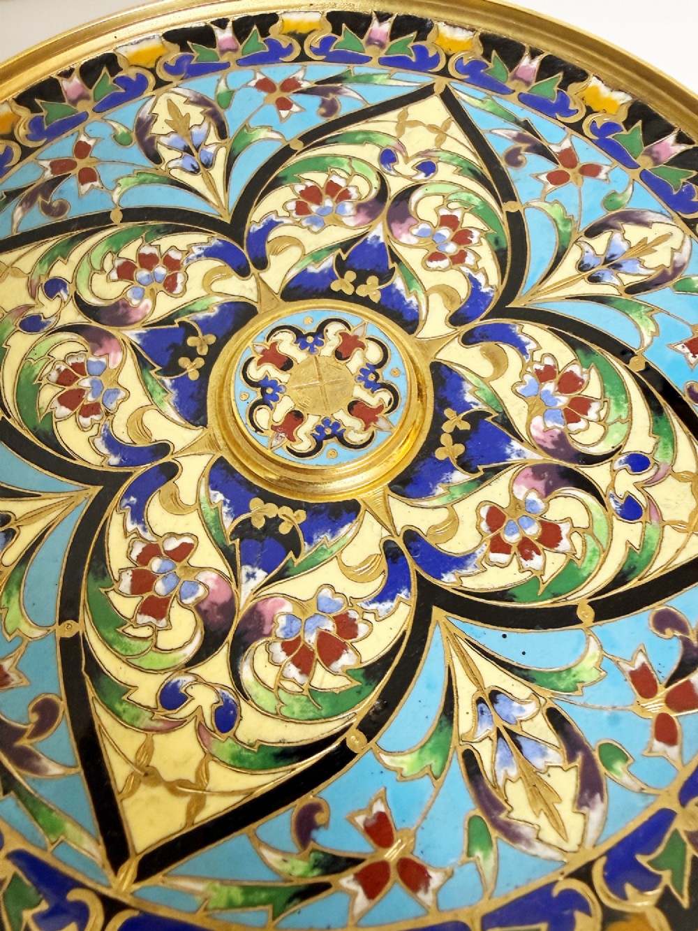 A 19th-century gilt bronze tazza featuring polychrome champleve enamel inlay across the shallow dish, pedestal foot, and side handles. View VI