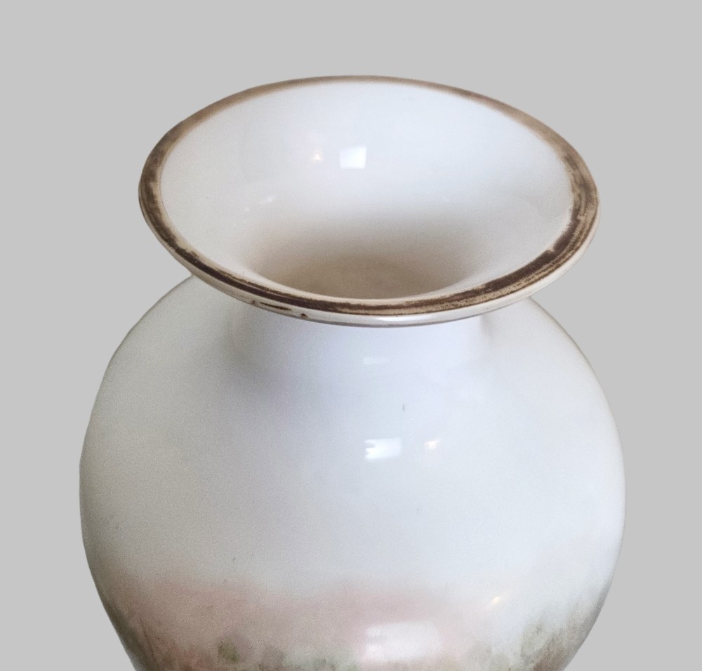 A pair of white porcelain baluster vases decorated with painted scenes of cherubs playing musical instruments in a garden, finished with gilt rims. View VI