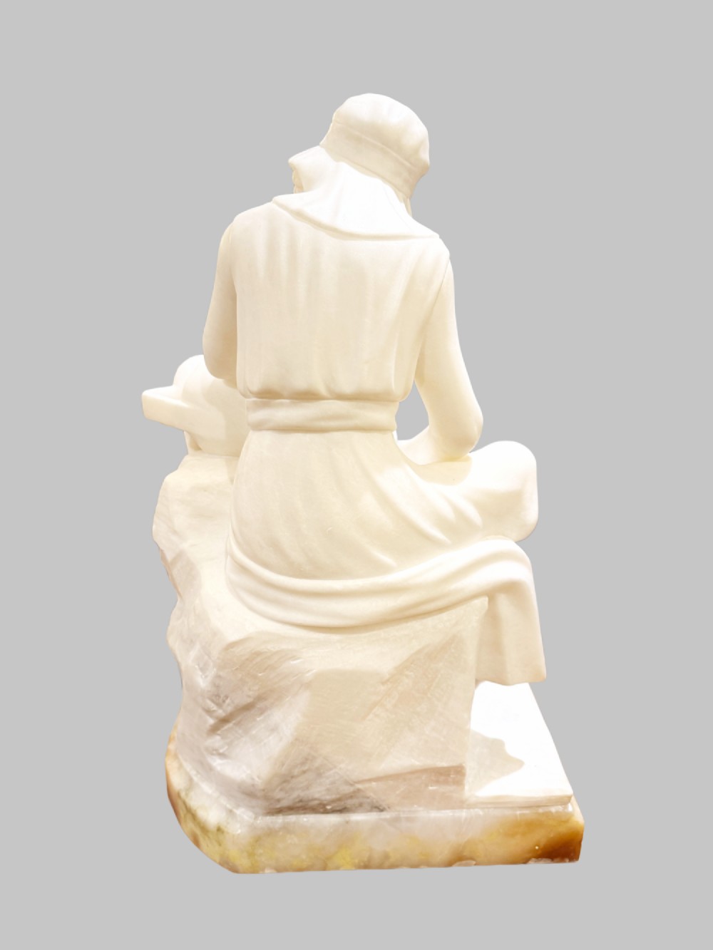 A carved white alabaster sculpture depicting a seated young maiden resting her chin on her hand beside a pitcher, mounted on a rectangular honey-coloured marble base. View VII