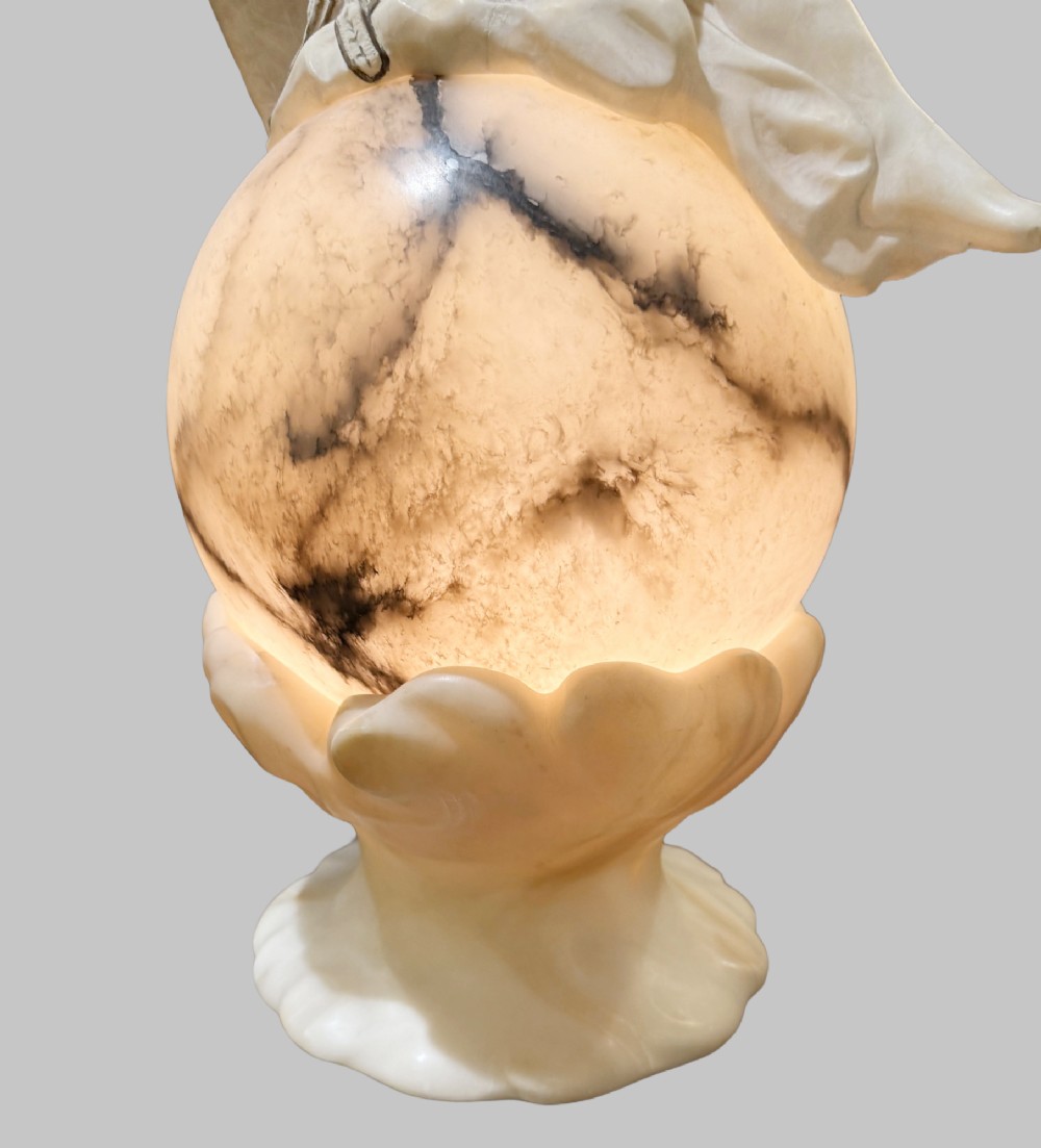 An Art Deco carved alabaster sculpture featuring a female dancer posed atop an illuminated marble orb resting on a shell-shaped pedestal base. View III