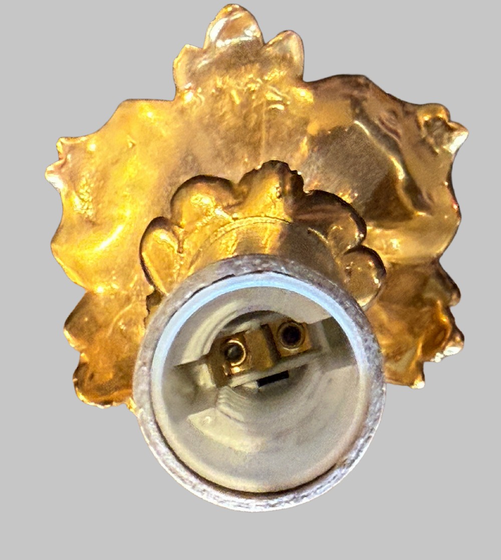 A pair of gilt bronze two-light wall sconces featuring elaborate Rococo scrolling acanthus leaf metalwork and cream candle sleeves. View VII