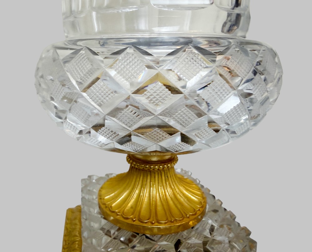 A clear cut-crystal urn-shaped vase featuring fluted body detailing, diamond-pattern cutting, and a gilt bronze rim and square pedestal base. View III