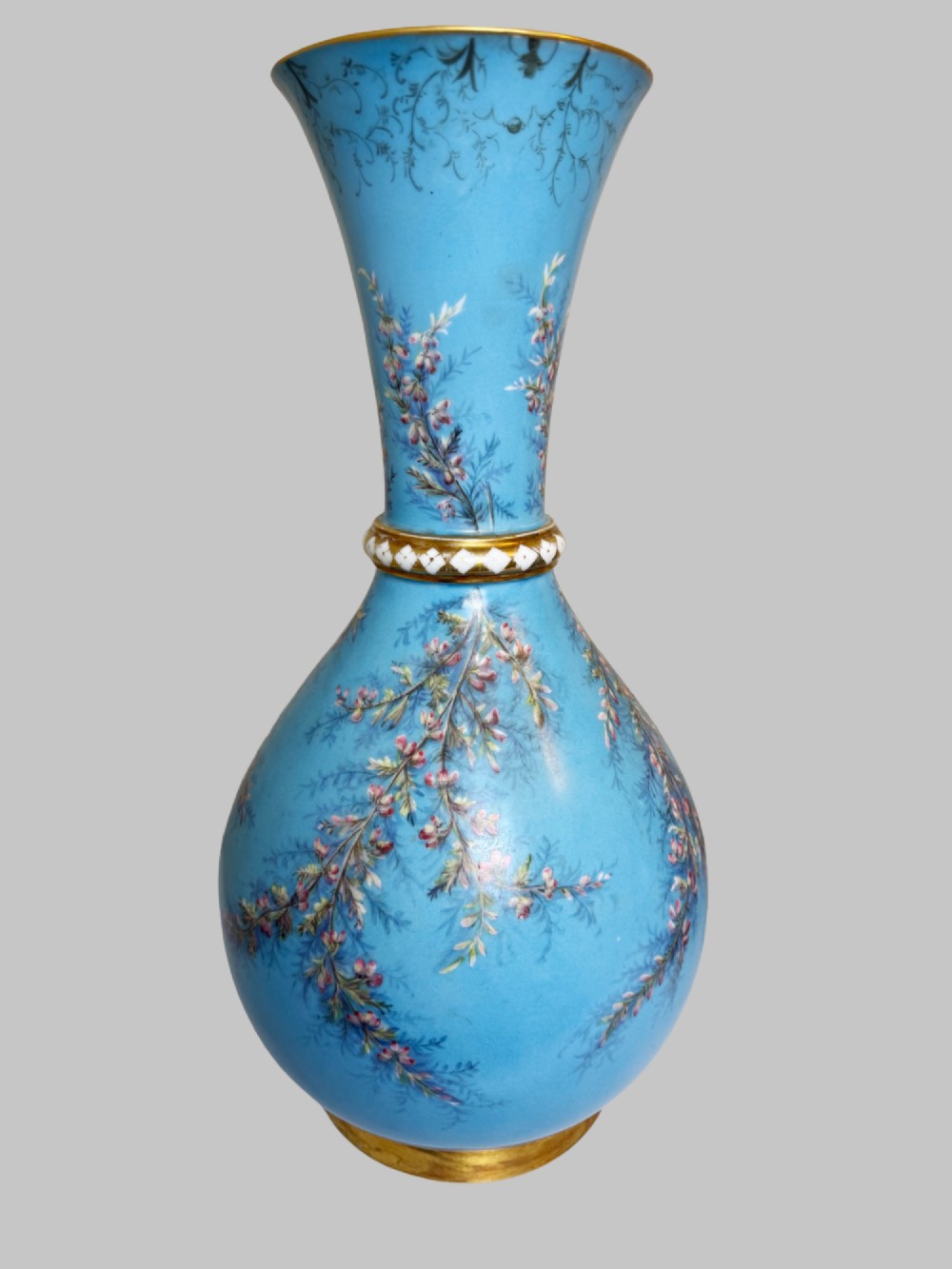 A pair of tall sky blue porcelain vases with bulbous bases, hand-painted floral branch motifs, and gilded rims and pedestals. View II