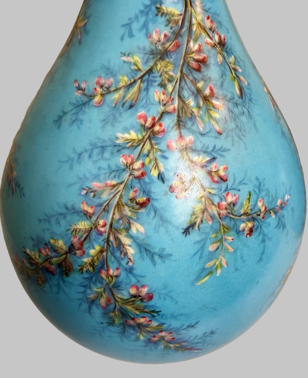 A pair of tall sky blue porcelain vases with bulbous bases, hand-painted floral branch motifs, and gilded rims and pedestals. View V