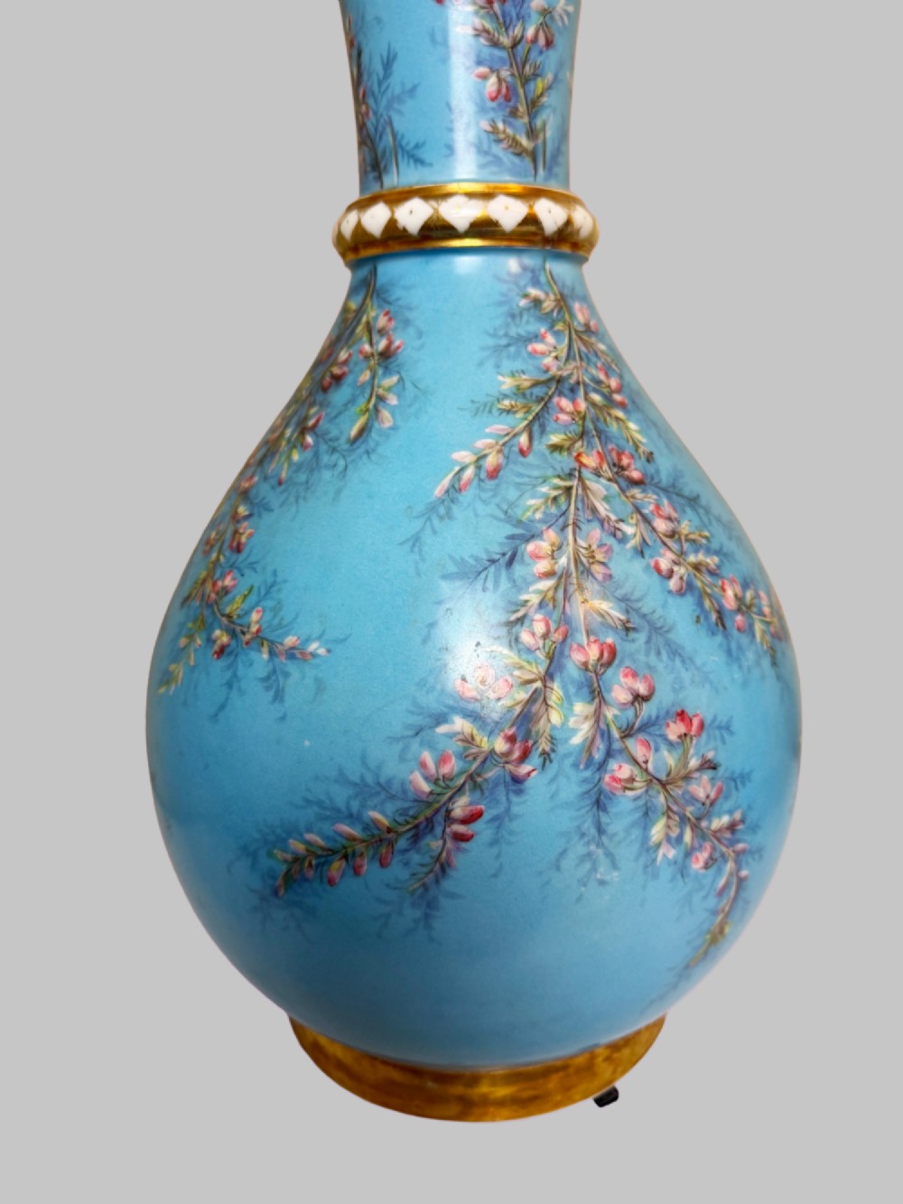 A pair of tall sky blue porcelain vases with bulbous bases, hand-painted floral branch motifs, and gilded rims and pedestals. View VI