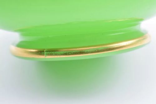 fig 1. A pair of apple green opaline glass vases with raised botanical leaf designs and gilded rims.
