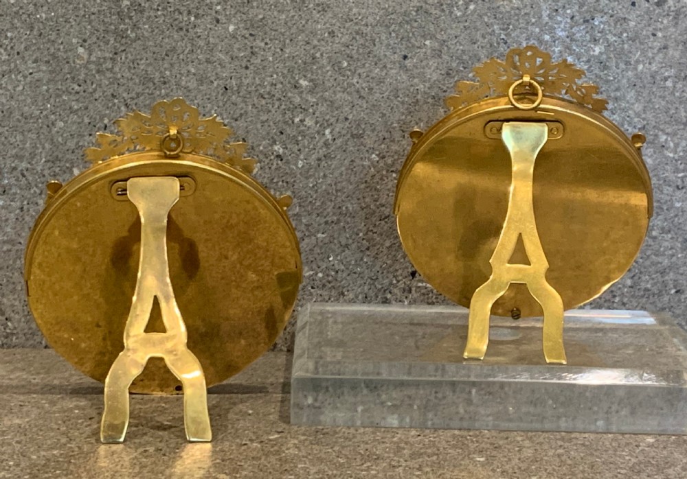 A pair of circular French Napoleon III gilt bronze and red enamel picture frames featuring decorative bow crests and floral garland detailing. View V