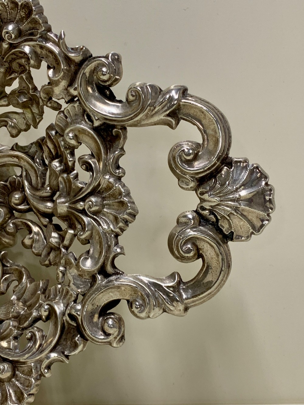 An oval antique silver basket featuring intricate openwork scrollwork, foliage motifs, and two integrated side handles. View III