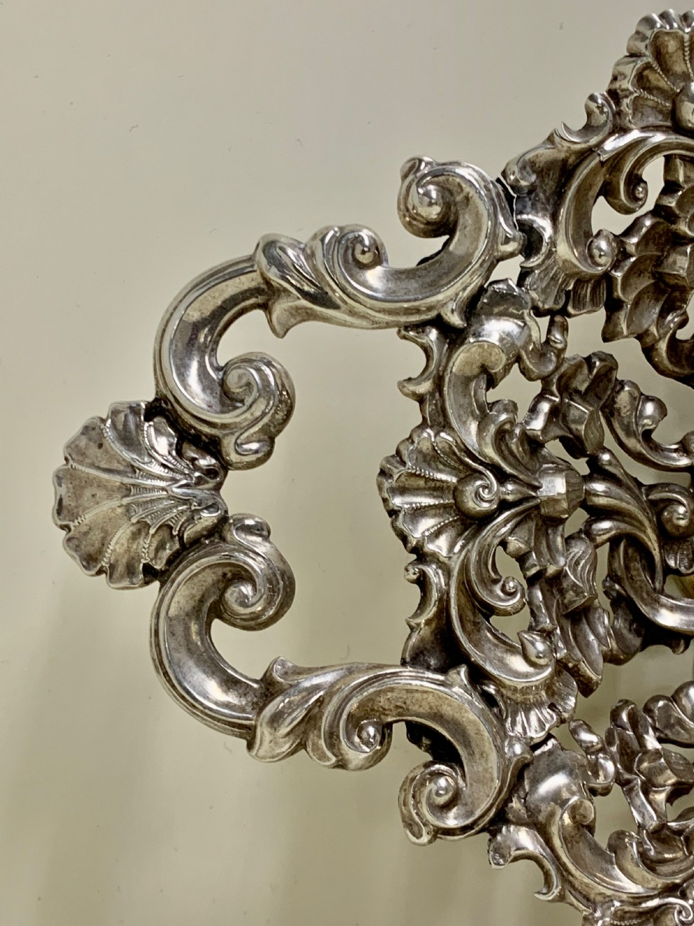 An oval antique silver basket featuring intricate openwork scrollwork, foliage motifs, and two integrated side handles. View IV