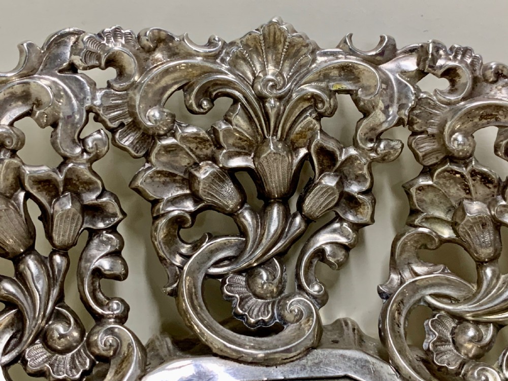 An oval antique silver basket featuring intricate openwork scrollwork, foliage motifs, and two integrated side handles. View VI