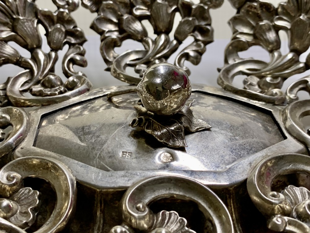 An oval antique silver basket featuring intricate openwork scrollwork, foliage motifs, and two integrated side handles. View IX