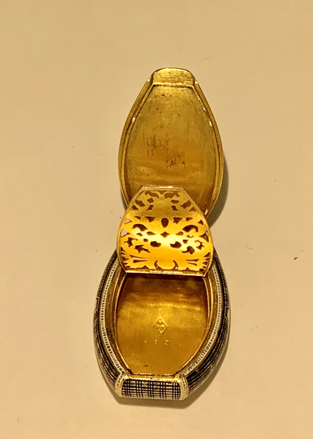 A late 18th-century oval gold vinaigrette box with a central royal blue enamel panel decorated with a shell motif and bordered by green stone accents. View XVII