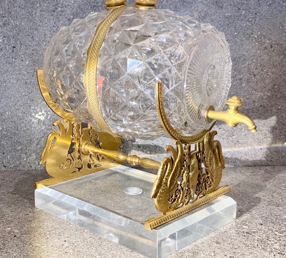 A French Charles X cut crystal glass barrel with gilt bronze swan-form mounts and an integrated tap set on a clear glass base. View VI