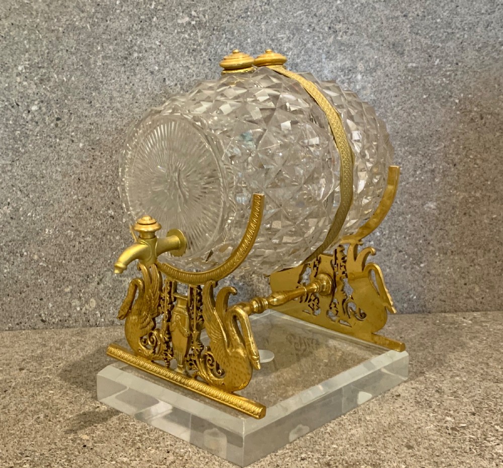 A French Charles X cut crystal glass barrel with gilt bronze swan-form mounts and an integrated tap set on a clear glass base. View VII