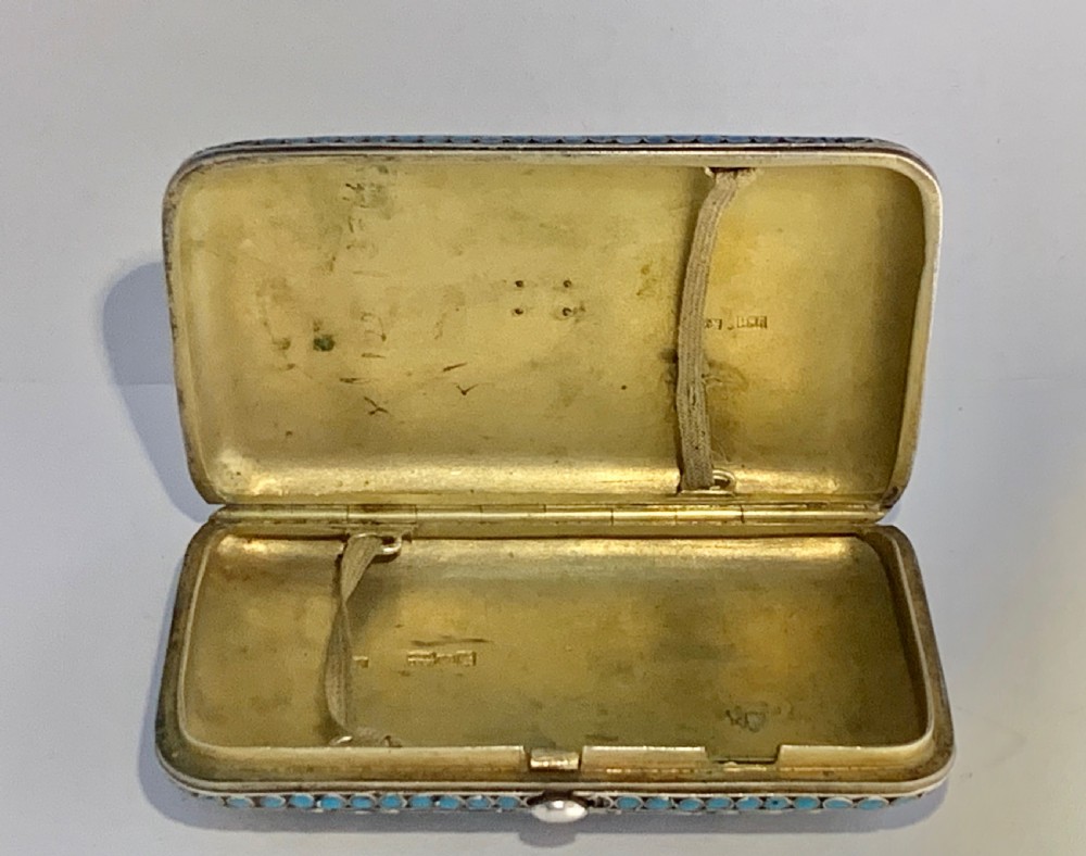 A rectangular silver-gilt box decorated with blue, white, and turquoise cloisonne enamel scroll motifs. View VII
