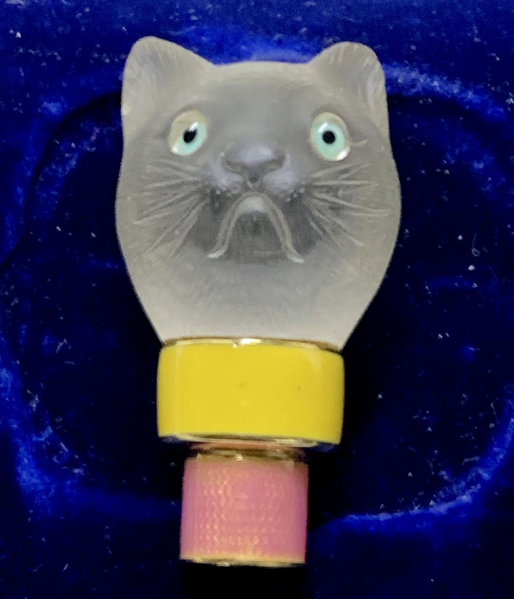 A carved frosted rock crystal cat head featuring green eyes, mounted atop an 18k gold collar with yellow and pink guilloche enamel. View VII