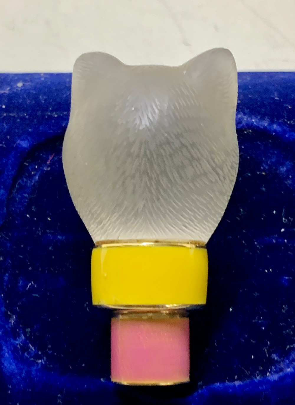 A carved frosted rock crystal cat head featuring green eyes, mounted atop an 18k gold collar with yellow and pink guilloche enamel. View IX