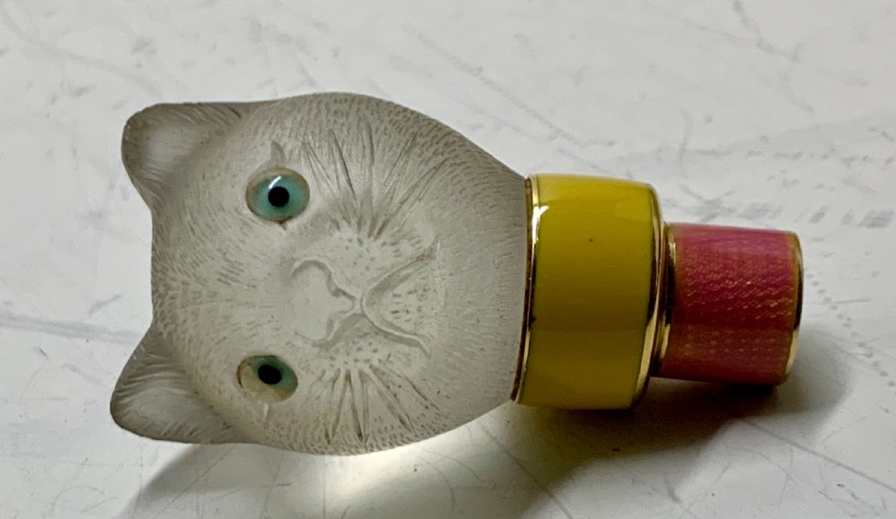 A carved frosted rock crystal cat head featuring green eyes, mounted atop an 18k gold collar with yellow and pink guilloche enamel. View XIII