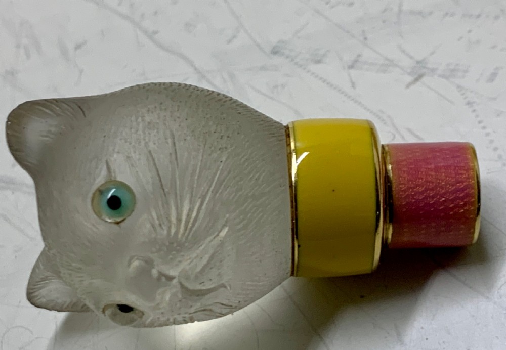 A carved frosted rock crystal cat head featuring green eyes, mounted atop an 18k gold collar with yellow and pink guilloche enamel. View XV