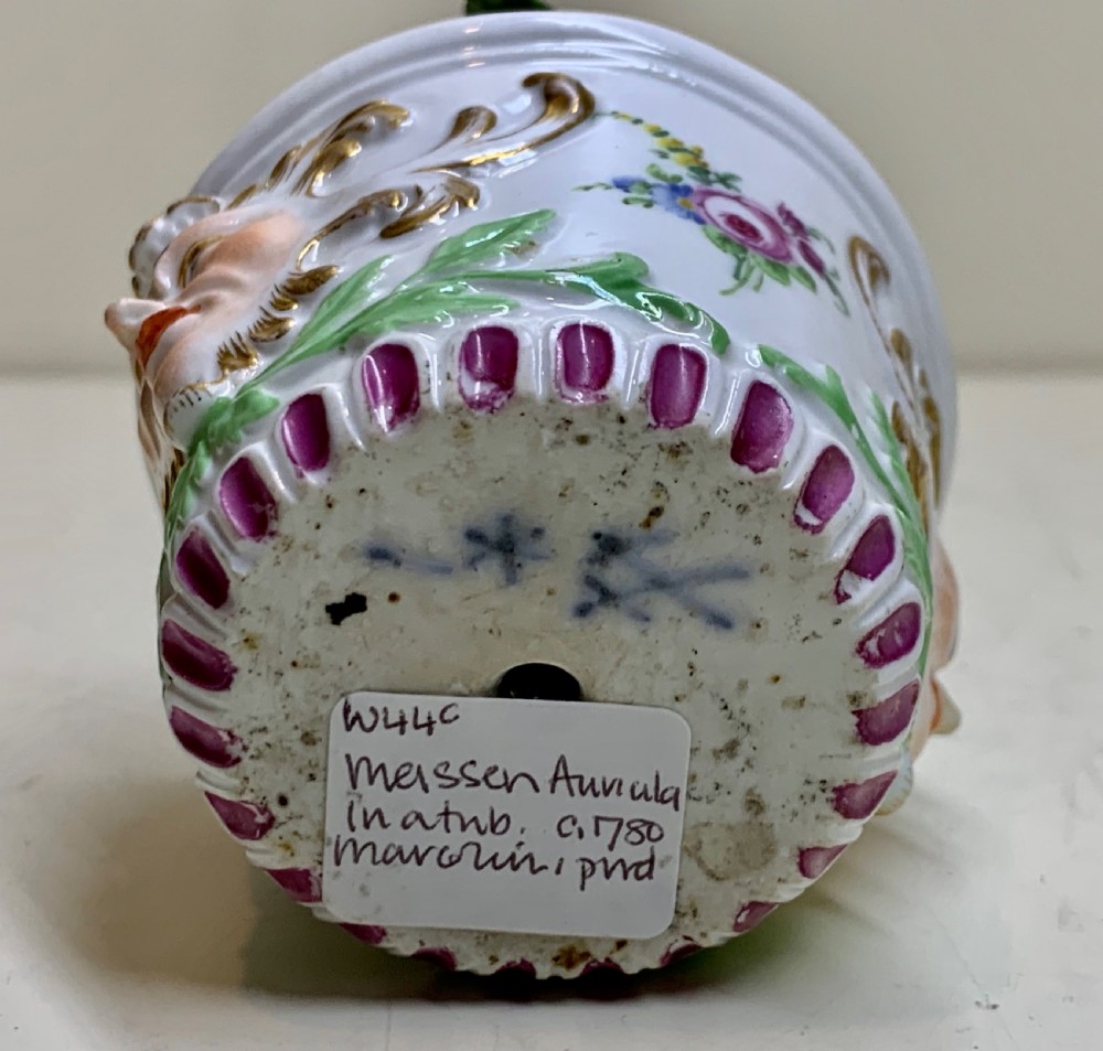 An 18th-century Meissen porcelain botanical sculpture featuring purple flowers and green leaves inside a white potted tub decorated with a mascaron mask and gold scrollwork. View VIII