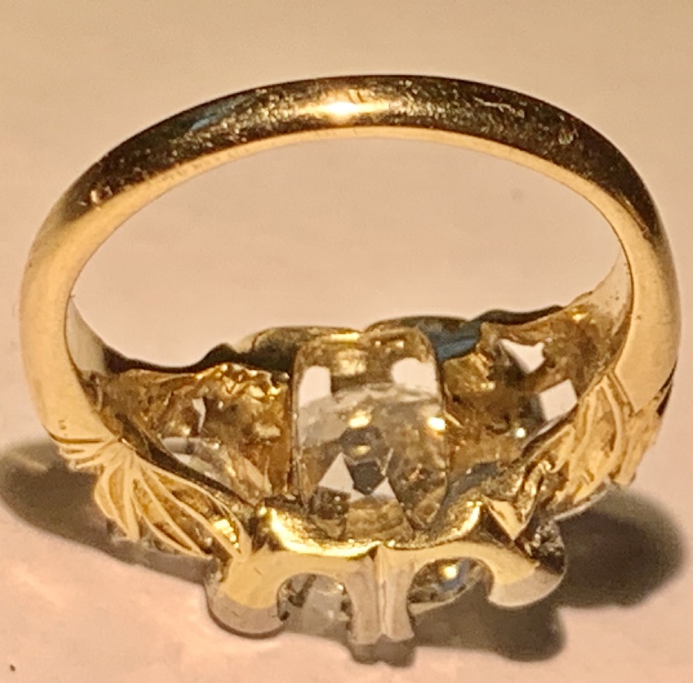 A Victorian 18ct yellow gold ring set with a central old European cut diamond flanked by smaller accent diamonds. View XI
