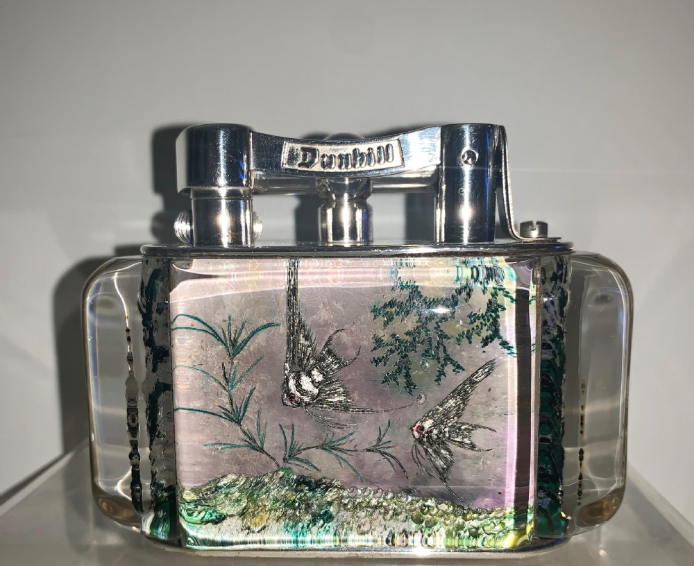A mid-century Dunhill Aquarium table lighter featuring transparent acrylic panels reverse-carved with angelfish and aquatic plants beneath a silver-toned lift-arm mechanism. View II