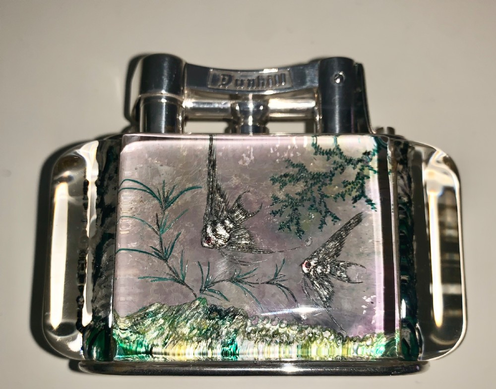 A mid-century Dunhill Aquarium table lighter featuring transparent acrylic panels reverse-carved with angelfish and aquatic plants beneath a silver-toned lift-arm mechanism. View VI