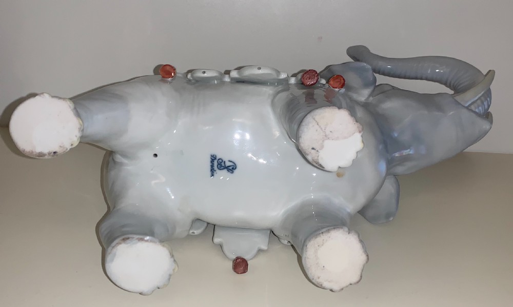 A large Dresden porcelain elephant figure painted in grey with a raised trunk and an ornate, colourful hand-painted saddle blanket. View V