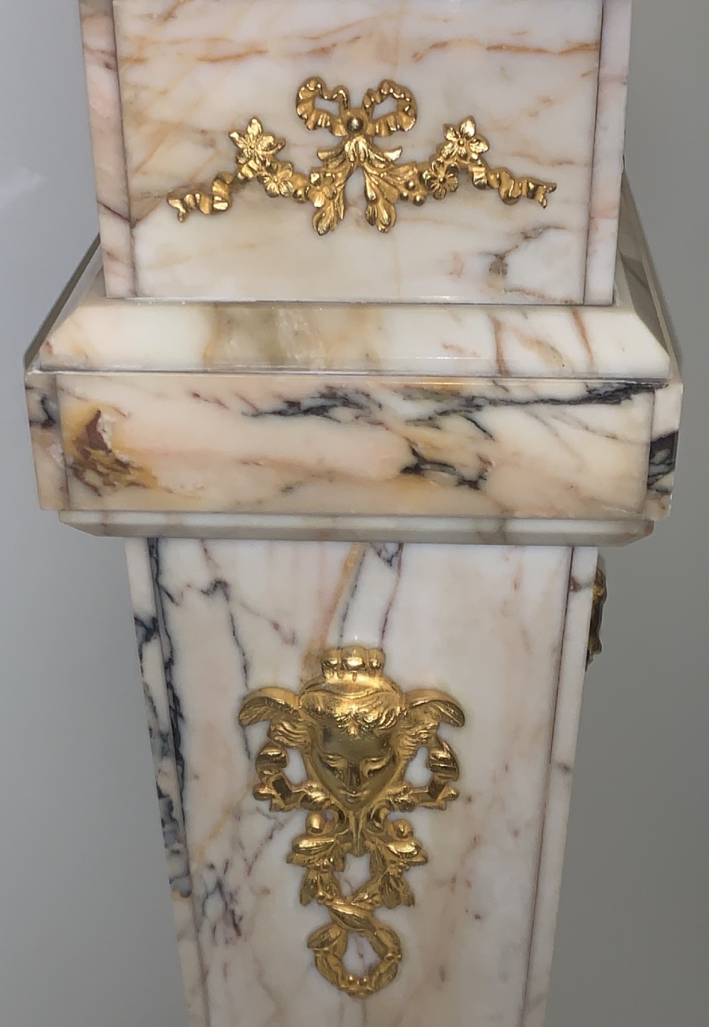 A tapered beige veined marble pedestal stand featuring ornate gilt bronze mounts and a square swivel top set upon a stepped base. View IX