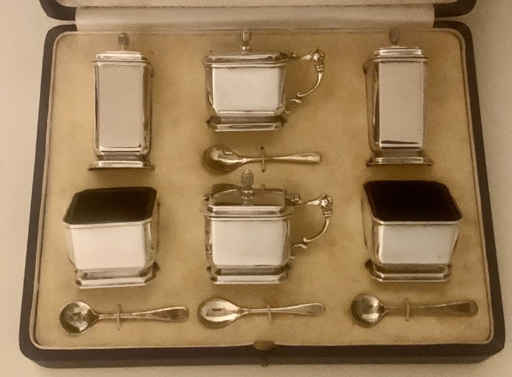 A six-piece Art Deco silver condiment set with matching spoons presented inside a fitted blue presentation box. View V