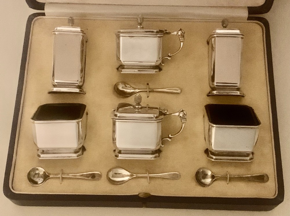 A six-piece Art Deco silver condiment set with matching spoons presented inside a fitted blue presentation box. View II