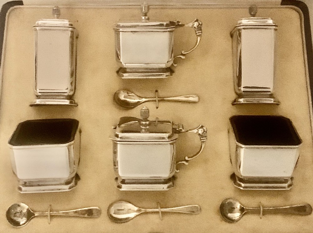 A six-piece Art Deco silver condiment set with matching spoons presented inside a fitted blue presentation box. View IV