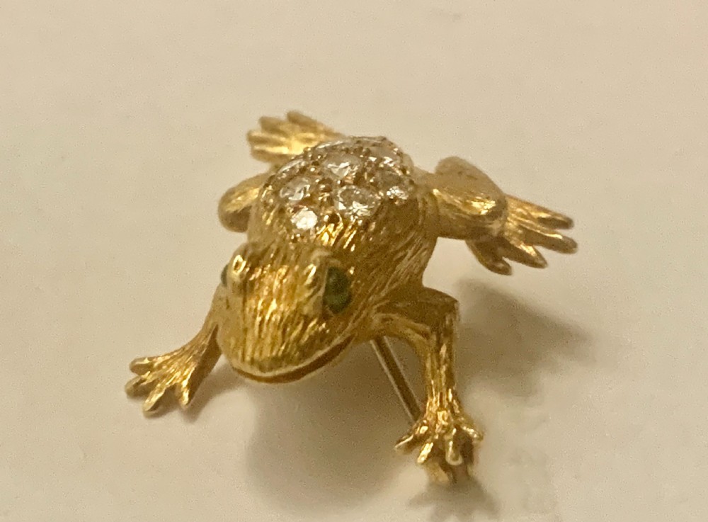 A textured gold frog brooch set with diamonds along its back and green gemstone eyes. View III