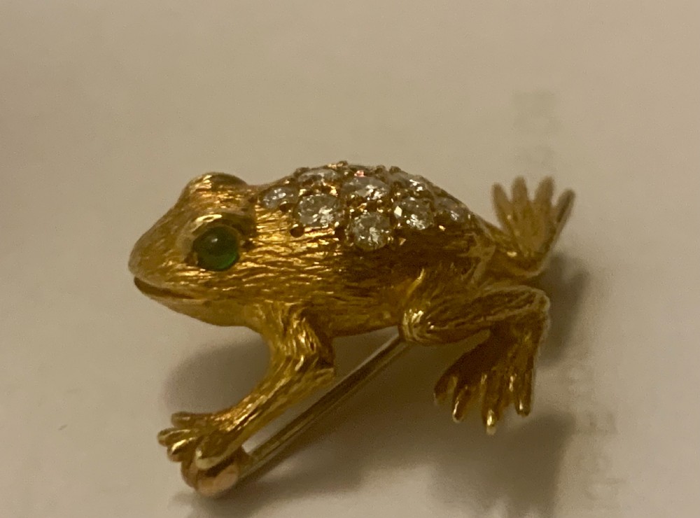 A textured gold frog brooch set with diamonds along its back and green gemstone eyes. View IV