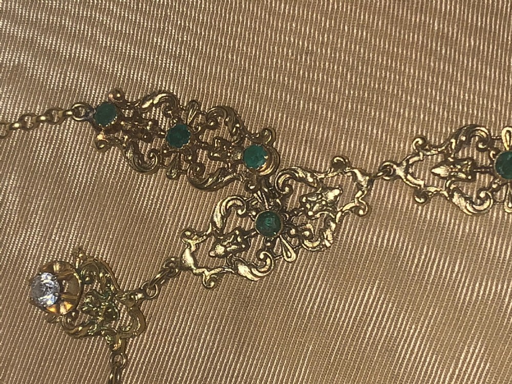 A Victorian 9ct gold lavaliere necklace featuring openwork scrolled motifs, central bezel-set round garnets, and hanging seed pearl drops. View III