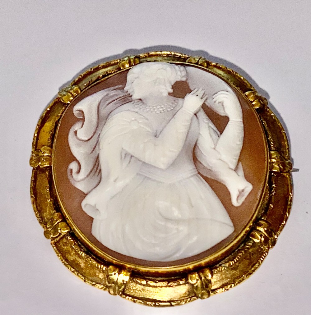 An antique circular brooch featuring a hand-carved shell cameo of a classical female figure set in a textured 15ct yellow gold frame. View VI