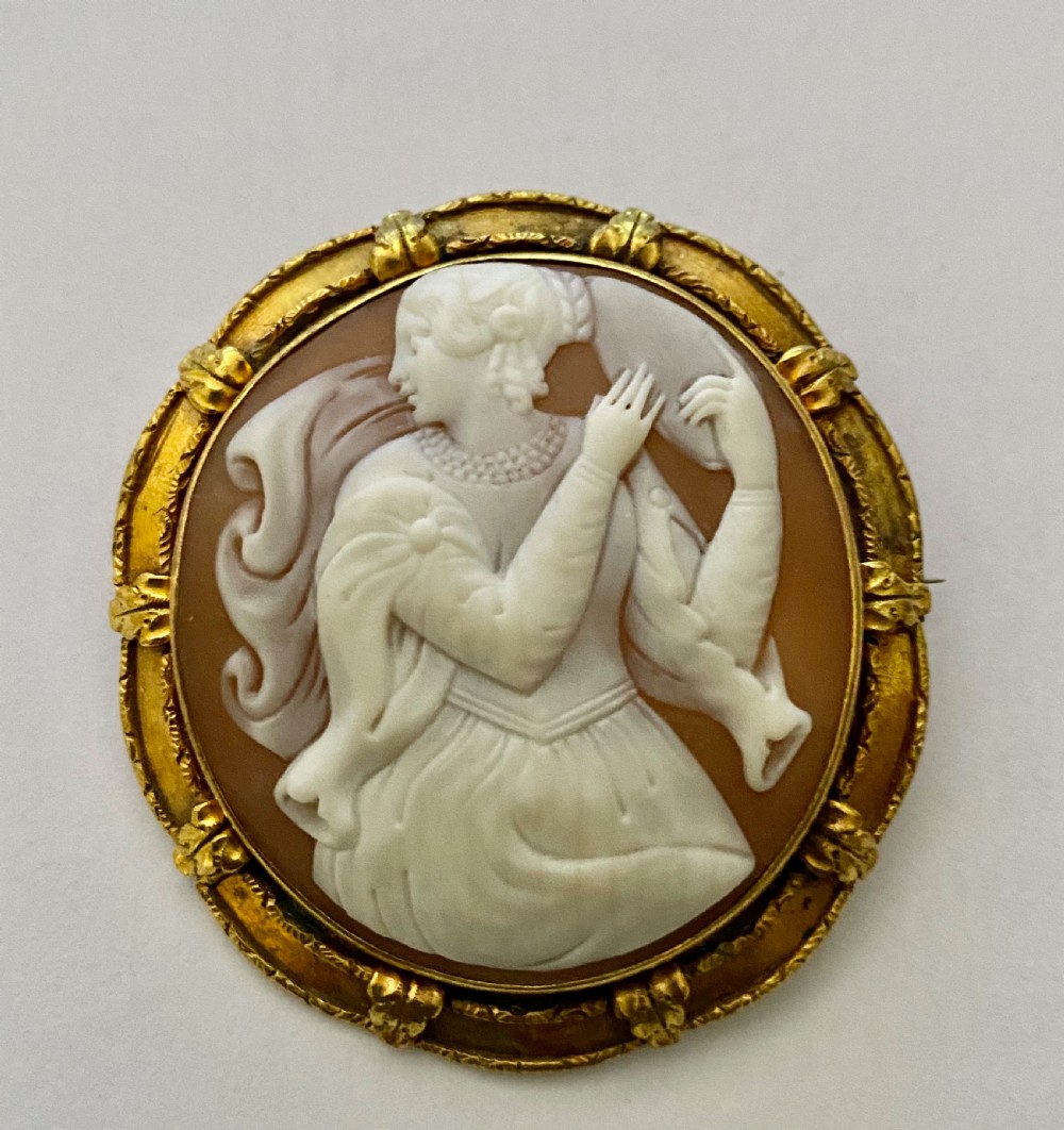 An antique circular brooch featuring a hand-carved shell cameo of a classical female figure set in a textured 15ct yellow gold frame. View VIII
