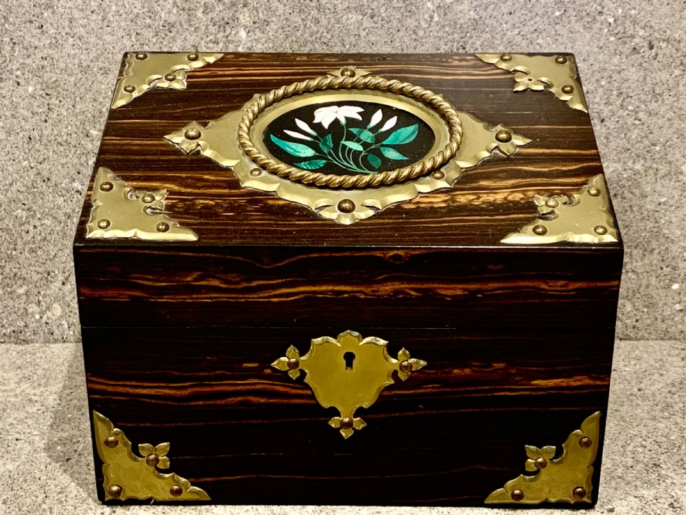 A dark striped coromandel wood stationery box with brass corner mounts, a central oval pietra dura floral plaque, and a brass keyhole escutcheon. View II