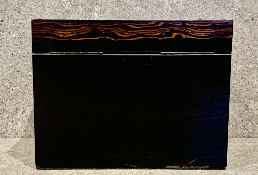 A dark striped coromandel wood stationery box with brass corner mounts, a central oval pietra dura floral plaque, and a brass keyhole escutcheon. View VII