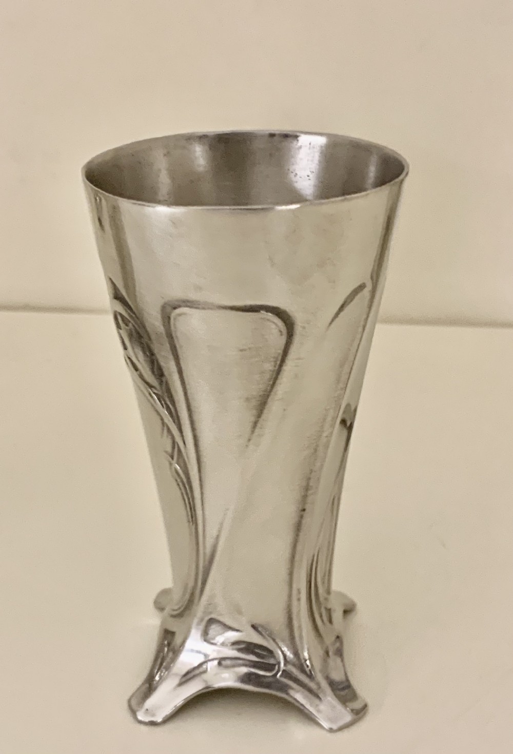 An Art Nouveau silvered pewter liqueur set comprising a tall spouted decanter with organic handles and six matching small tapered cups. View X