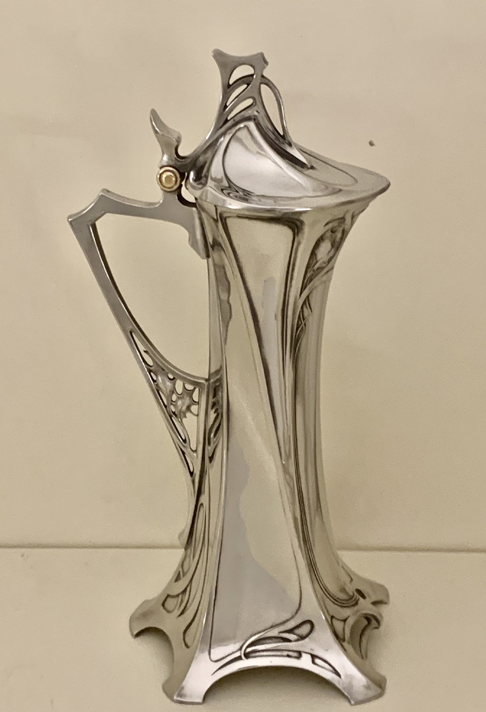 An Art Nouveau silvered pewter liqueur set comprising a tall spouted decanter with organic handles and six matching small tapered cups. View XV