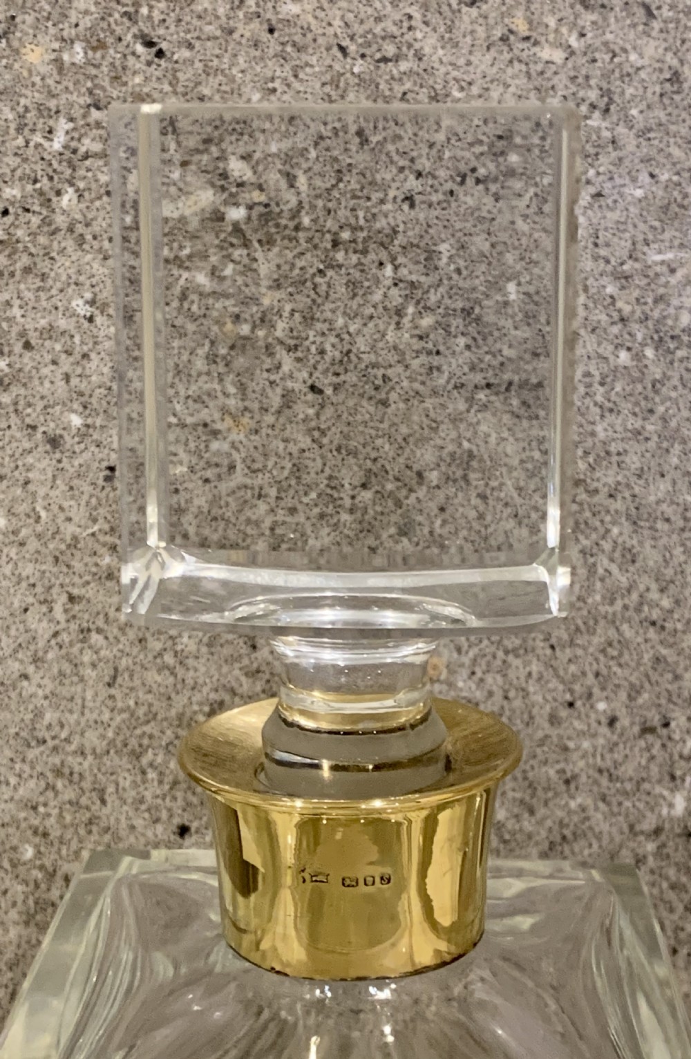 A pair of rectangular clear glass spirit decanters featuring gold-toned silver collars around the necks and matching square glass stoppers. View X