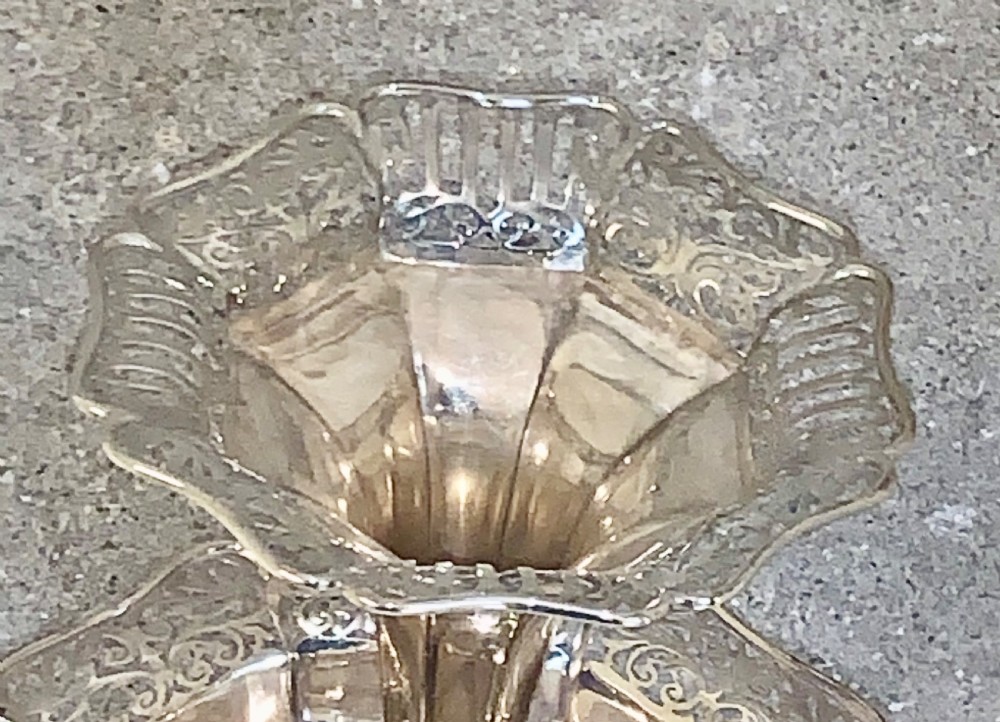 An Edwardian sterling silver two-tiered centrepiece with pierced decorative borders, a flared pedestal column, and a shaped hexagonal base. View II