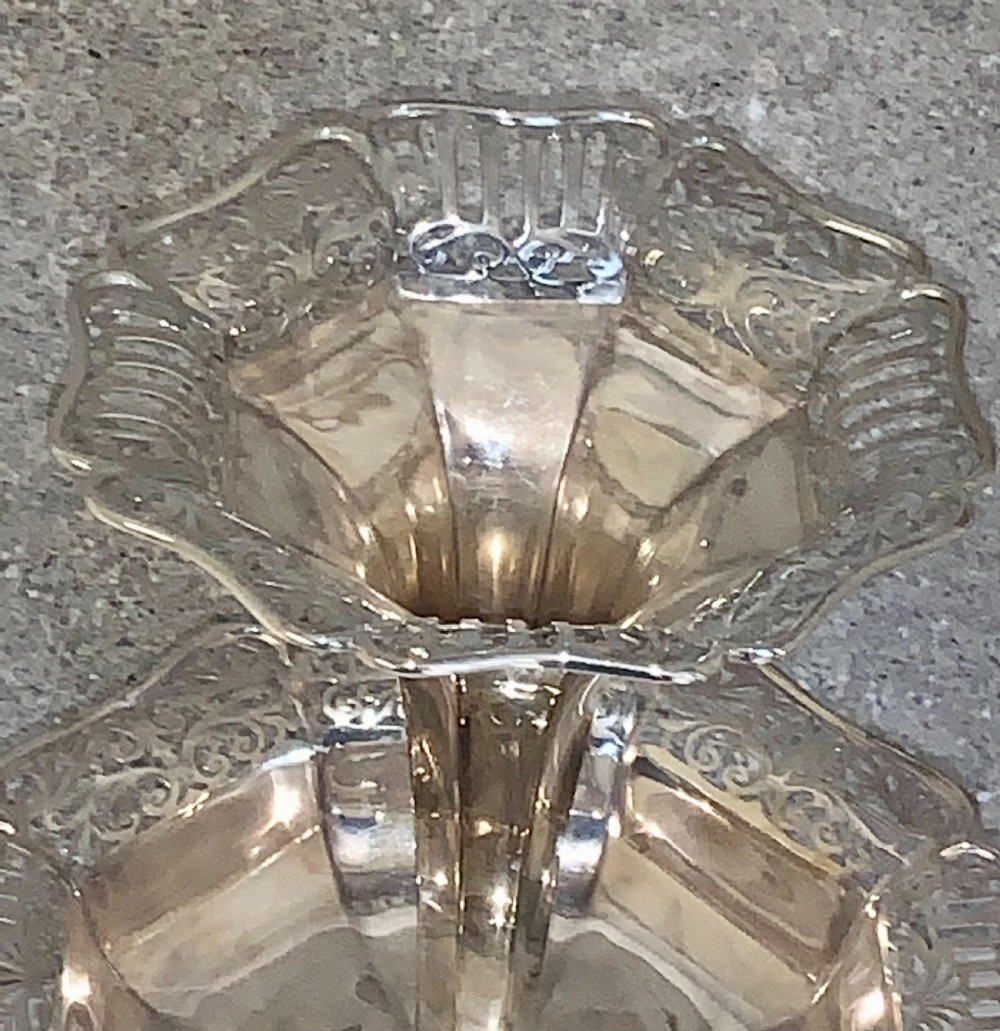 An Edwardian sterling silver two-tiered centrepiece with pierced decorative borders, a flared pedestal column, and a shaped hexagonal base. View III