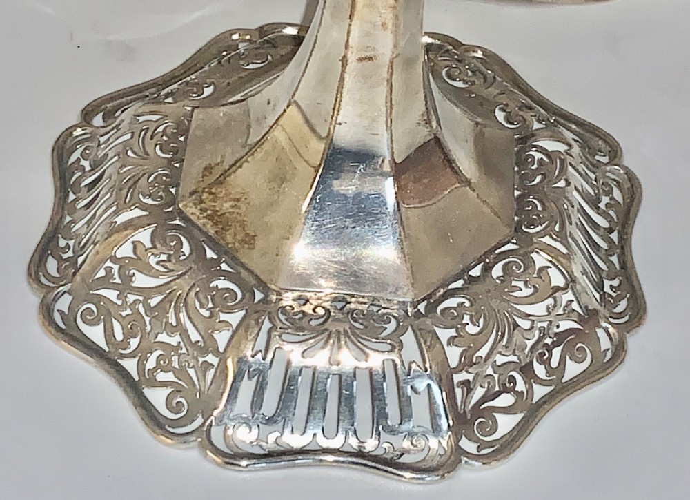 An Edwardian sterling silver two-tiered centrepiece with pierced decorative borders, a flared pedestal column, and a shaped hexagonal base. View V