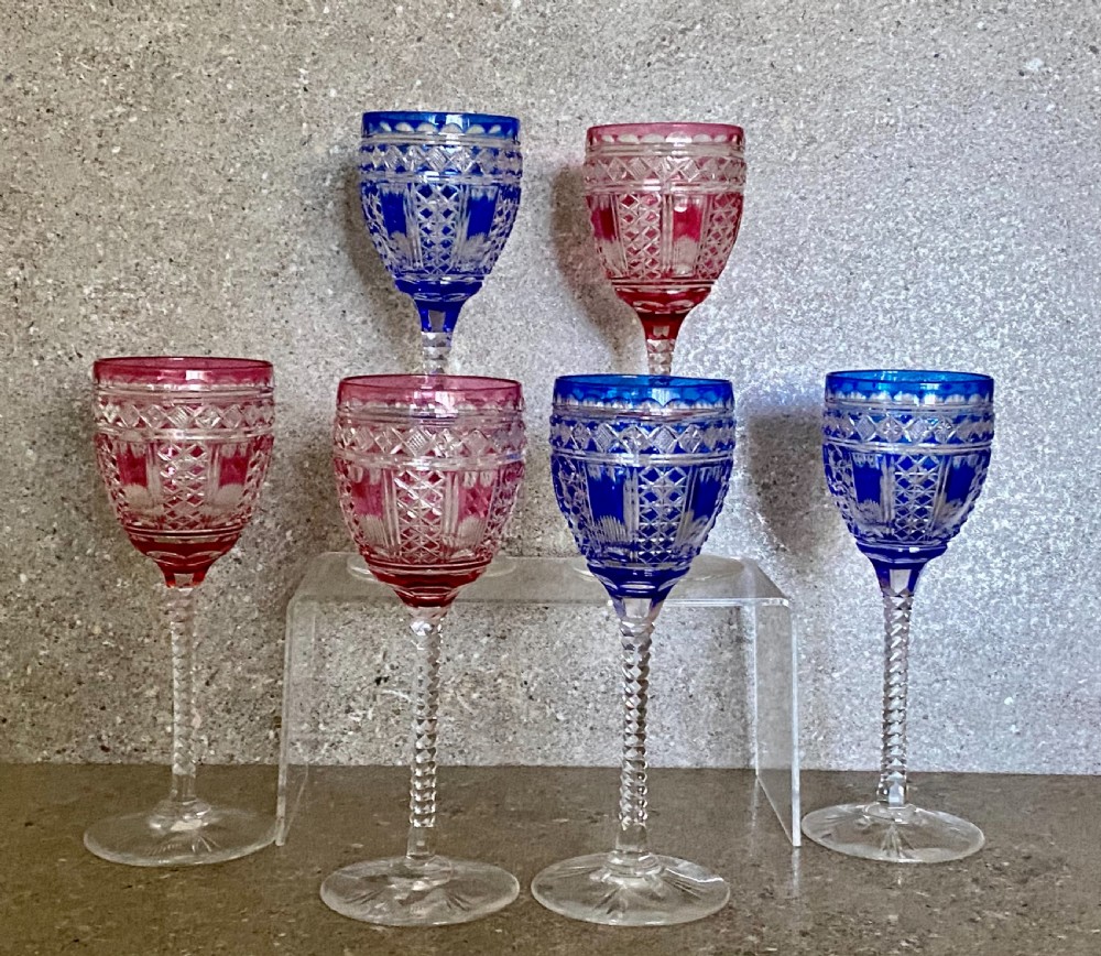 A set of six cut-to-clear crystal wine glasses with alternating cobalt blue and ruby red bowls on tall faceted stems. View II