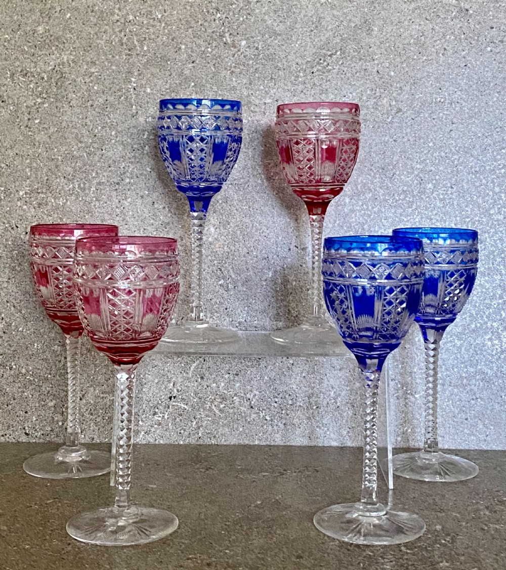 A set of six cut-to-clear crystal wine glasses with alternating cobalt blue and ruby red bowls on tall faceted stems. View IV